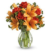 Online Christmas Flowers Delivery of Orange Lily Red Roses in Vase 12 Flowers to Hyderabad